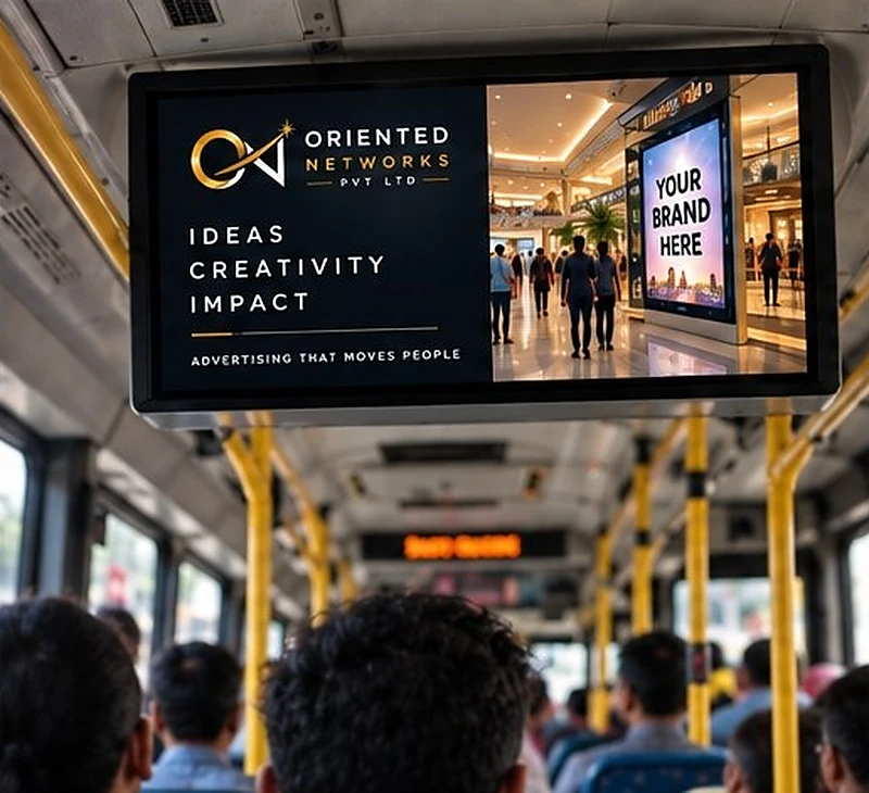 A ceiling-mounted bus screen showing 'Ideas, Creativity, Impact', with rows of passengers below.